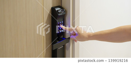 Hand press PIN number for smart digital door lock while open or close the door at home or apartment. NFC Technology, Fingerprint scan, keycard, smartphone and contactless lifestyle concepts Hand press PIN number for smart digital door lock while open or close the door at home or apartment. NFC Technology, Fingerprint scan, keycard, smartphone and contactless lifestyle concepts 139919216