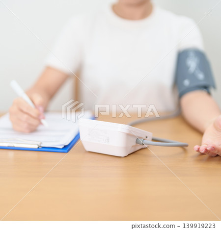 woman checking Blood pressure by Blood pressure monitor with Cuff. Systolic, SYS, Diastolic, DIA, Pulse, Hypertension, Hypotension, Heart rate, Cardiovascular Disease and May World hypertension day 139919223