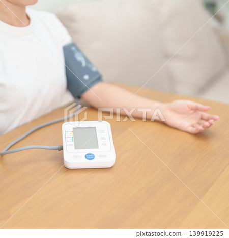 woman checking Blood pressure by Blood pressure monitor with Cuff. Systolic, SYS, Diastolic, DIA, Pulse, Hypertension, Hypotension, Heart rate, Cardiovascular Disease and May World hypertension day woman checking Blood pressure by Blood pressure monitor with Cuff. Systolic, SYS, Diastolic, DIA, Pulse, Hypertension, Hypotension, Heart rate, Cardiovascular Disease and May World hypertension day 139919225
