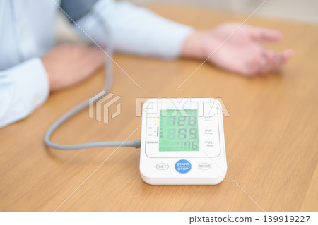Man checking Blood pressure by Blood pressure monitor with Cuff. Systolic, SYS, Diastolic, DIA, Pulse, Hypertension, Hypotension, Heart rate, Cardiovascular Disease and May World hypertension day 139919227
