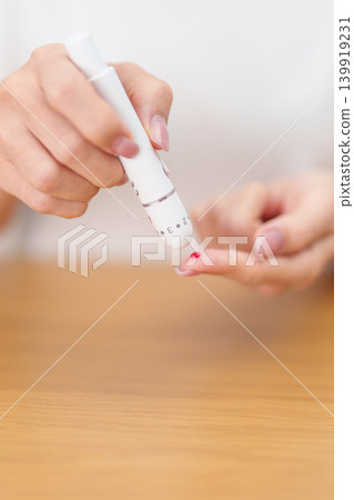 Hand using lancet pen on finger with Blood drop glucose testing or Diabetes checking by digital blood glucose meter. blood sugar level, Diabetes Day, Glycemia, Hypoglycemia, Hyperglycemia and insulin Hand using lancet pen on finger with Blood drop glucose testing or Diabetes checking by digital blood glucose meter. blood sugar level, Diabetes Day, Glycemia, Hypoglycemia, Hyperglycemia and insulin 139919231