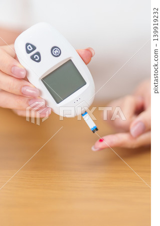 Hand checking Diabetes or Blood glucose self testing by digital blood glucose meter with lancet pen. high blood sugar level, World Diabetes Day, Glycemia, Hypoglycemia, Hyperglycemia and insulin 139919232