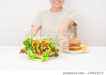 happy woman choose vegetables Salad and thumbs up gesture. Healthy and Unhealthy Food Choice, Calories and Nutrition of vegetables and Hamburger. dieting, weight loss control, junk food and lifestyle happy woman choose vegetables Salad and thumbs up gesture. Healthy and Unhealthy Food Choice, Calories and Nutrition of vegetables and Hamburger. dieting, weight loss control, junk food and lifestyle 139919273