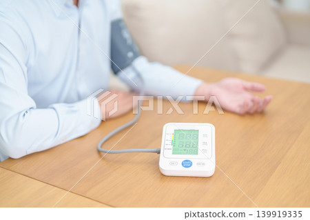 Man checking Blood pressure by Blood pressure monitor with Cuff. Systolic, SYS, Diastolic, DIA, Pulse, Hypertension, Hypotension, Heart rate, Cardiovascular Disease and May World hypertension day 139919335