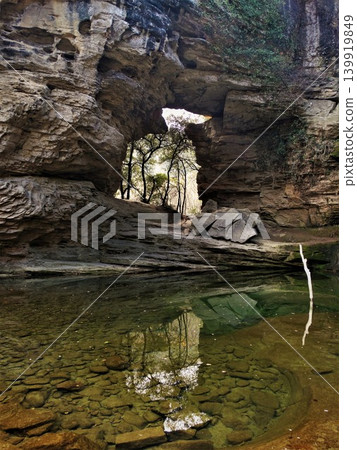 Natural rock arch spanning over clear water pool Natural rock arch spanning over clear water pool 139919849