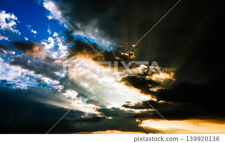 A scene of rays of light shining through gaps in the clouds at sunset in Biei, Hokkaido, during the summer. A scene of rays of light shining through gaps in the clouds at sunset in Biei, Hokkaido, during the summer. 139920136