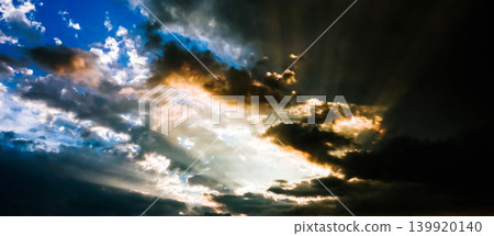 A scene of rays of light shining through gaps in the clouds at sunset in Biei, Hokkaido, during the summer. A scene of rays of light shining through gaps in the clouds at sunset in Biei, Hokkaido, during the summer. 139920140