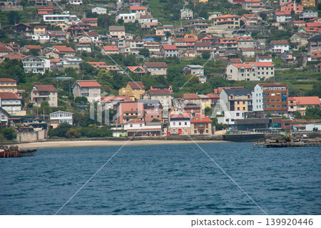 View of small coastal villages with their beach on the Vigo estuary from a boat in Galicia View of small coastal villages with their beach on the Vigo estuary from a boat in Galicia 139920446