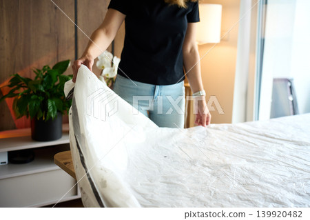 Woman covering work table with plastic sheet for craft project Woman covering work table with plastic sheet for craft project 139920482