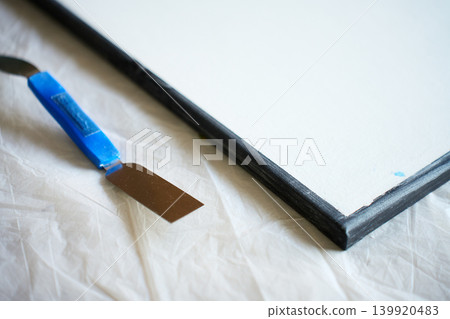 Textured canvas art with spatula on covered work surface Textured canvas art with spatula on covered work surface 139920483