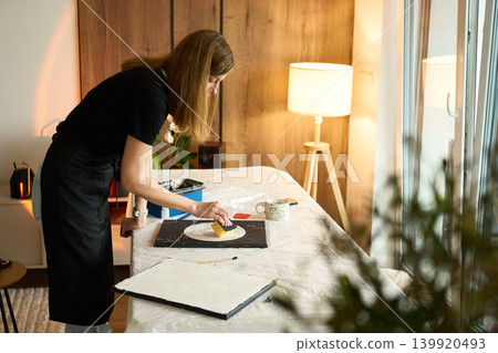 Woman making handmade wall decor with sponge on canvas Woman making handmade wall decor with sponge on canvas 139920493
