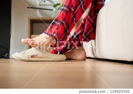 Person waking up and putting on slippers by bed 139920502