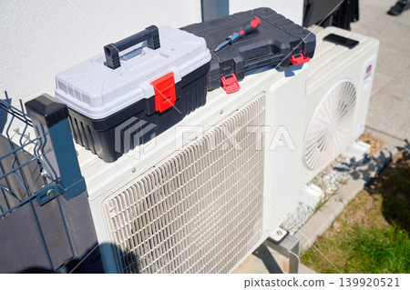 Toolboxes placed on outdoor heat pump unit for maintenance Toolboxes placed on outdoor heat pump unit for maintenance 139920521