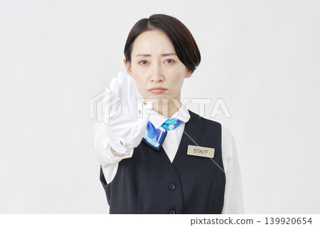Female staff member, receptionist/bus guide, striking a stop pose against a white background. Female staff member, receptionist/bus guide, striking a stop pose against a white background. 139920654