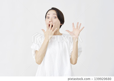 Surprised middle-aged woman against a white background Surprised middle-aged woman against a white background 139920680