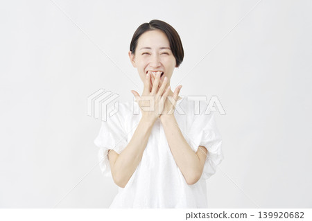一位中年婦女在白色背景前露出驚訝的笑容。 139920682