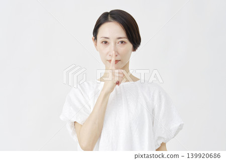 一位中年婦女以神秘的姿勢站在白色背景前 139920686