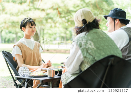 A girl and her family enjoying day camping and barbecues at a park and campsite. A girl and her family enjoying day camping and barbecues at a park and campsite. 139921527
