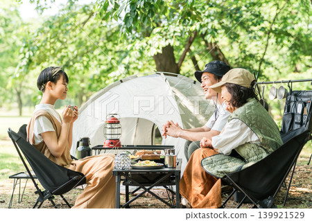 一個親密的家庭喜歡在公園和露營地進行一日露營和燒烤。 一個親密的家庭喜歡在公園和露營地進行一日露營和燒烤。 139921529