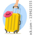 Yellow suitcase with a hat pulled by a woman s hand on a white background. Travel suitcase 139921555