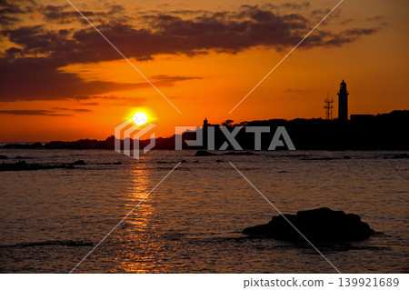 從千葉縣野島崎欣賞的絕美日落。橙色的天空和夕陽,以及燈塔和島嶼的輪廓,構成了一幅引人注目、美不勝收的畫面。 從千葉縣野島崎欣賞的絕美日落。橙色的天空和夕陽,以及燈塔和島嶼的輪廓,構成了一幅引人注目、美不勝收的畫面。 139921689