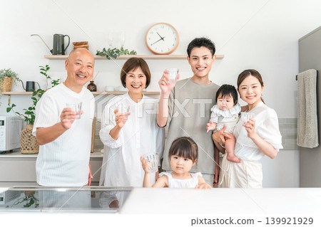 一家三代人在家裡的廚房喝水。 一家三代人在家裡的廚房喝水。 139921929
