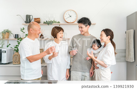 A three-generation family drinking water in their home kitchen. A three-generation family drinking water in their home kitchen. 139921930