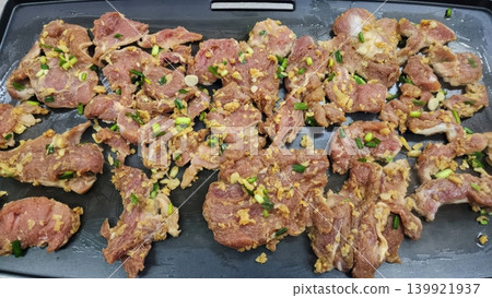 Marinated Pork Slices with Garlic and Green Onions Cooking on a Flat Griddle Marinated Pork Slices with Garlic and Green Onions Cooking on a Flat Griddle 139921937