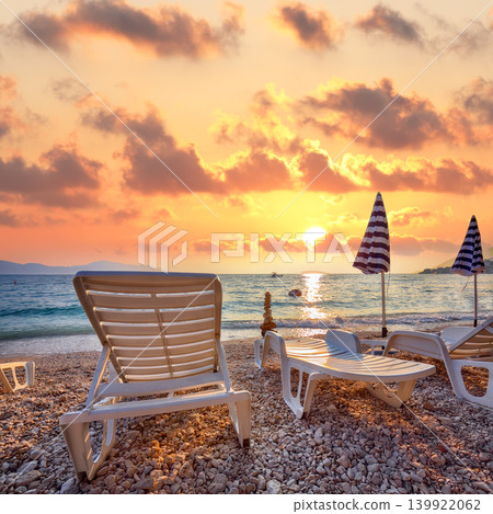 Amazing Sun loungers and beach umbrellas at sunset on the beach of Gradac in Makarska riviera. 139922062