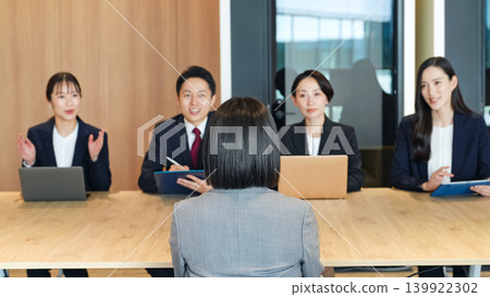 A group of business professionals being interviewed in an office A group of business professionals being interviewed in an office 139922302
