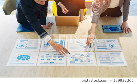 A group of business people having a meeting while looking at documents in the office. A group of business people having a meeting while looking at documents in the office. 139922305