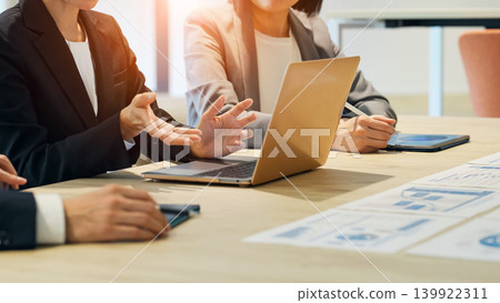 A group of business people having a meeting while looking at documents in the office. A group of business people having a meeting while looking at documents in the office. 139922311