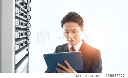 一位男性工程師正在檢查伺服器。 139922322