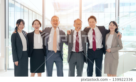 一群商務人士在辦公室裡互相摟著肩膀,開懷大笑。 一群商務人士在辦公室裡互相摟著肩膀,開懷大笑。 139922336
