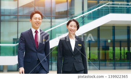 A group of male and female business professionals talking while walking down the street. A group of male and female business professionals talking while walking down the street. 139922365