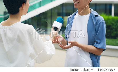一名男子在街頭接受採訪 一名男子在街頭接受採訪 139922397