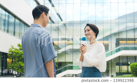 A female reporter interviews men on the street. A female reporter interviews men on the street. 139922398