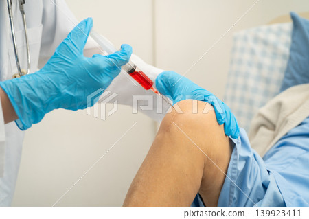 Asian doctor inject Hyaluronic acid platelet rich plasma into knee of senior woman. 139923411
