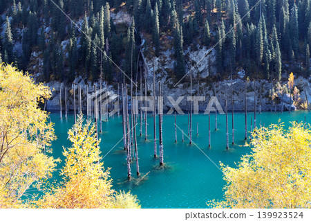 Picturesque autumn scenery of Kaindy lake with dead trees, Kolsay Lakes National Park, northern region of Tien Shan Mountains, Kazakhstan. Alpine Kaindy lake, Almaty region, Kazakhstan Picturesque autumn scenery of Kaindy lake with dead trees, Kolsay Lakes National Park, northern region of Tien Shan Mountains, Kazakhstan. Alpine Kaindy lake, Almaty region, Kazakhstan 139923524