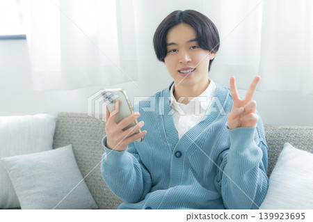 操作智能手機的一個年輕人 操作智能手機的一個年輕人 139923695