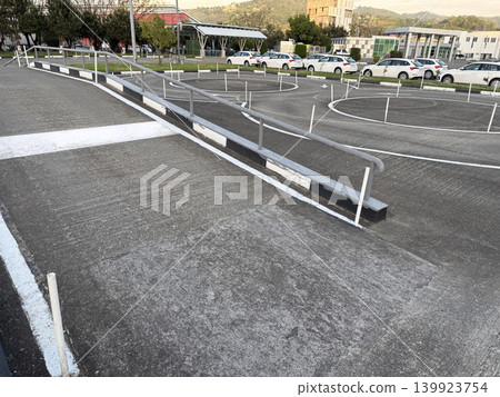 Ramps and circular paths in a vehicle training area near a city building at daylight Ramps and circular paths in a vehicle training area near a city building at daylight 139923754