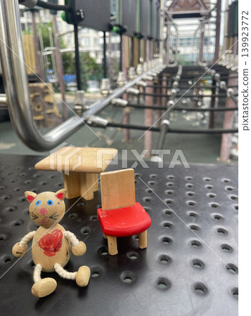 Small wooden toys arranged on a playground surface in an urban area during daylight hours 139923772