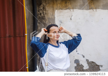 Smiling woman with long dark hair smiling and walking in old town 139924113