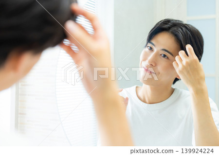 man looking in the mirror in the bathroom 139924224