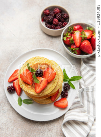 Stacking berry pancakes for a delicious breakfast meal Stacking berry pancakes for a delicious breakfast meal 139924395