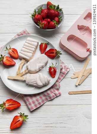 Homemade strawberry popsicles on white wooden table Homemade strawberry popsicles on white wooden table 139924411