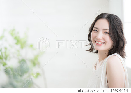 A close-up shot of a woman smiling in a room with natural light, showcasing her beauty and natural lifestyle, looking directly at the camera. A close-up shot of a woman smiling in a room with natural light, showcasing her beauty and natural lifestyle, looking directly at the camera. 139924414