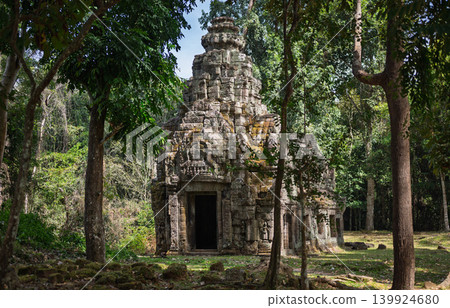 Ancient stone temple ruins hidden deep inside lush green tropical forest jungle featuring historic architectural details representing ancient Asian civilization heritage site Ancient stone temple ruins hidden deep inside lush green tropical forest jungle featuring historic architectural details representing ancient Asian civilization heritage site 139924680