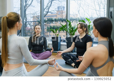 Women Meditating During Yoga Class In Gym Studio Women Meditating During Yoga Class In Gym Studio 139925052