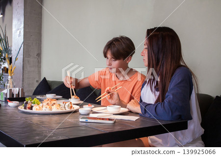 Pretty mother and child eating rolls in cafe 139925066